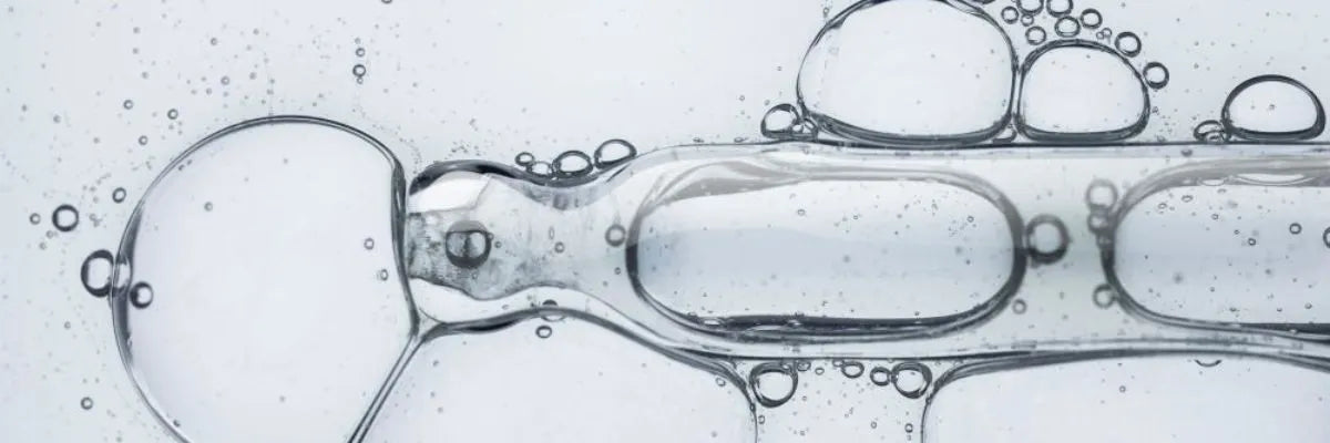 Close-up of clear liquid bubbles and droplets suspended in a transparent gel-like substance