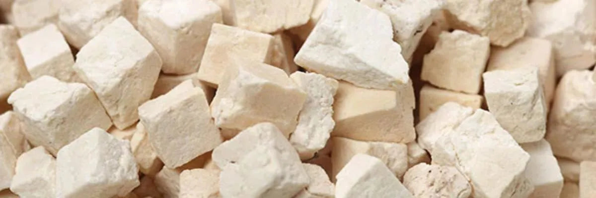 Close-up of beige and off-white irregular cube-shaped pieces of Poria Cocos extract