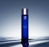 iS Clinical Daily Active Smoothing Toner bottle standing on a rippled, reflective water surface in soft blue light