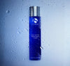 iS Clinical Daily Active Smoothing Toner bottle in front of misted glass beaded with water droplets