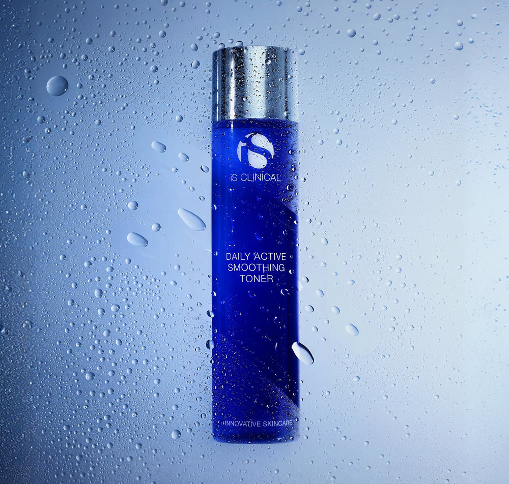 iS Clinical Daily Active Smoothing Toner bottle in front of misted glass beaded with water droplets