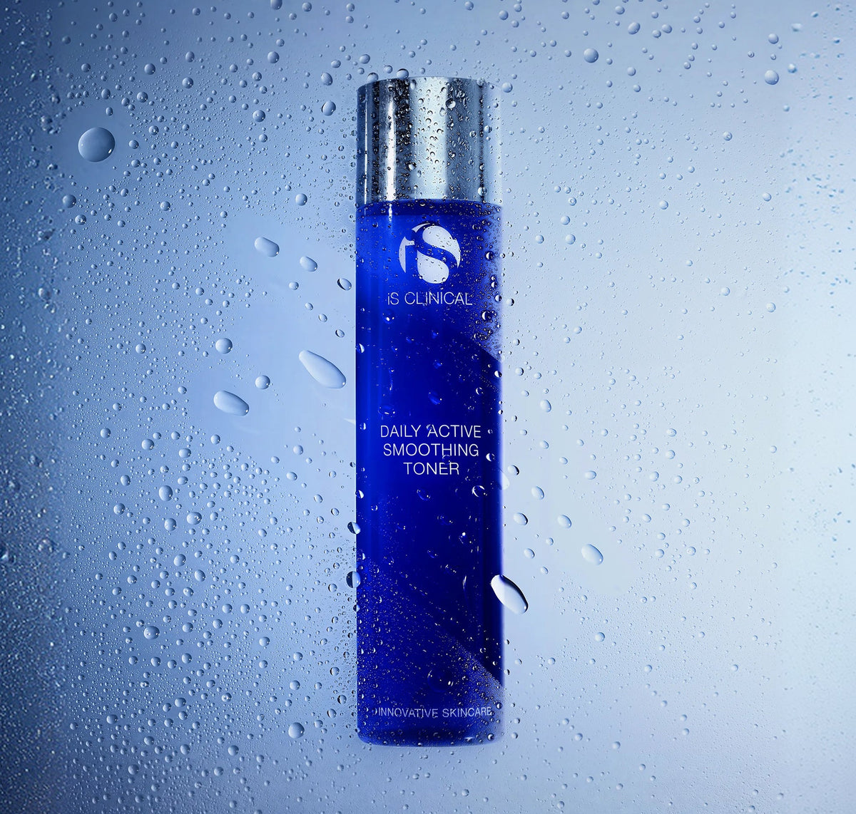 iS Clinical Daily Active Smoothing Toner bottle in front of misted glass beaded with water droplets