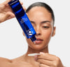Woman dispensing iS Clinical Daily Active Smoothing Toner from the bottle onto a cotton pad