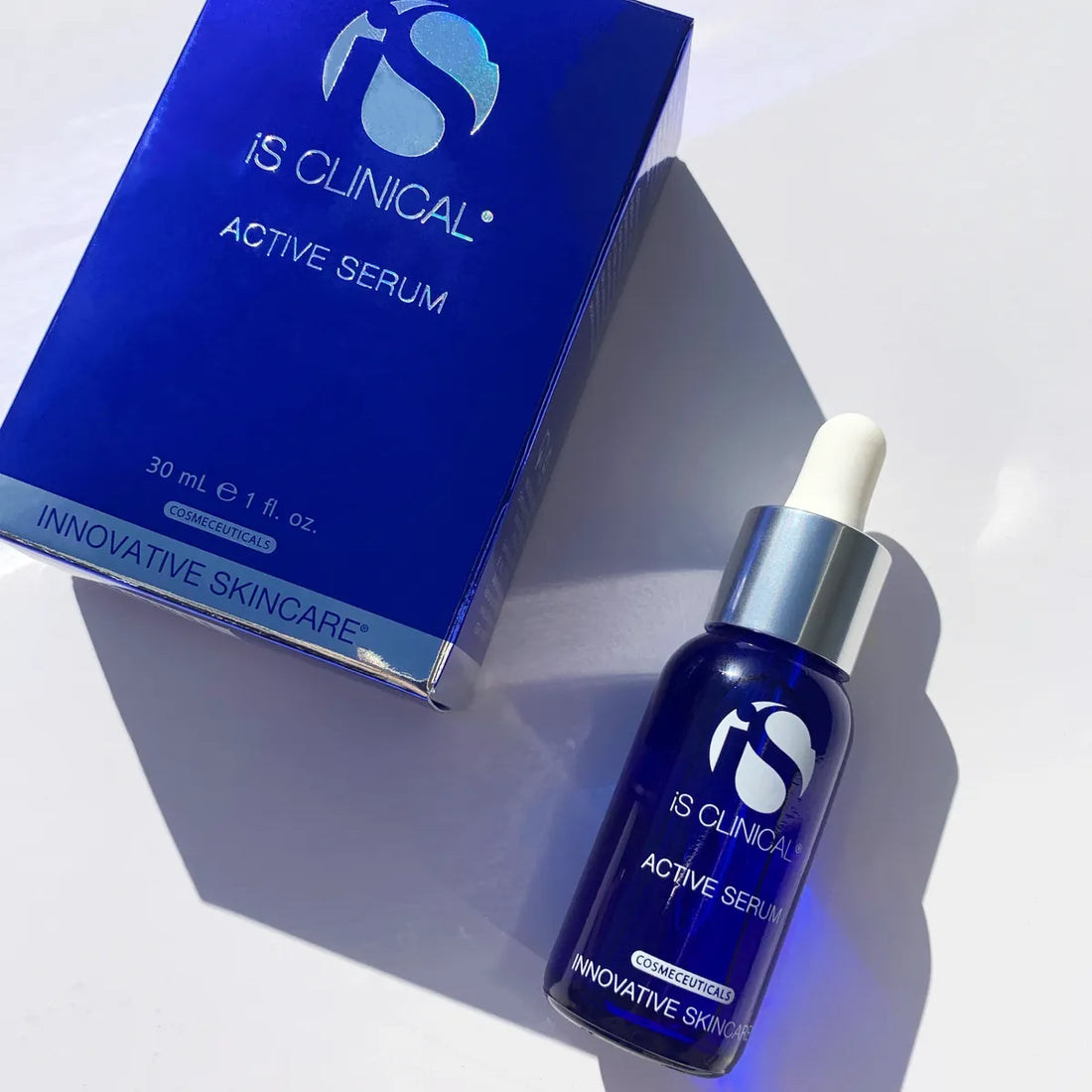 iS Clinical Active Serum blue glass dropper bottle next to matching blue box on white background