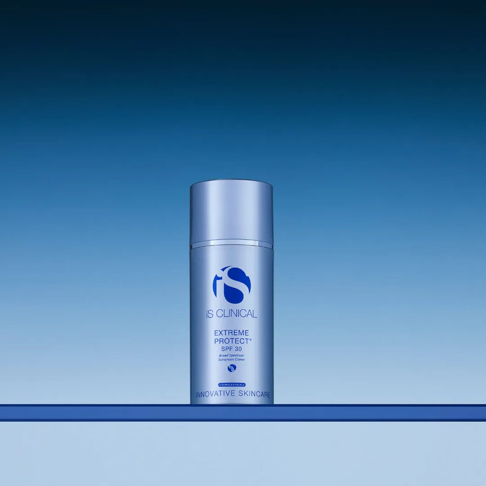 iS Clinical Extreme Protect SPF 30 sunscreen bottle with silver-blue packaging on blue gradient background