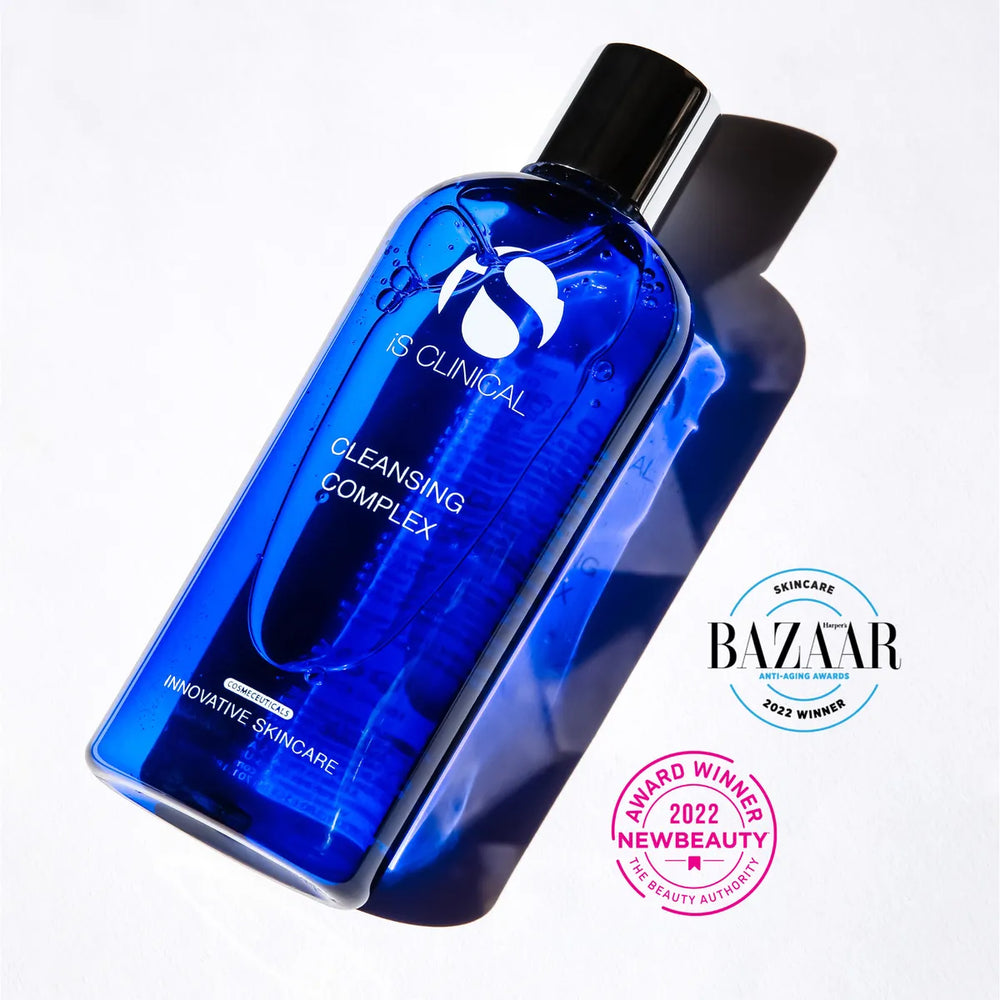 Blue translucent bottle of iS Clinical Cleansing Complex with black cap casting shadow on white background