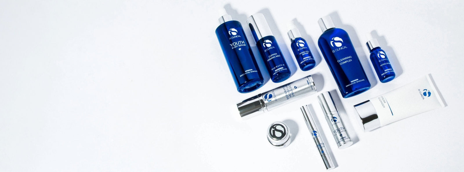 Collection of iS Clinical skincare products in blue and white packaging on a white background