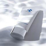 iS Clinical Warming Honey Cleanser tube with silver cap on white surface with soft shadows